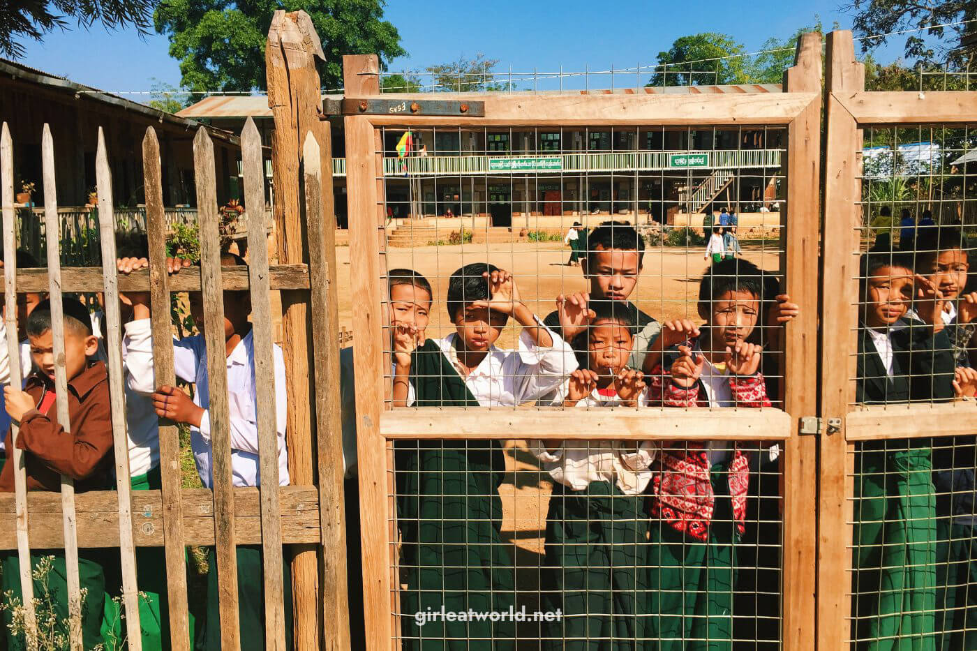 Indein kids watching soccer through school gate