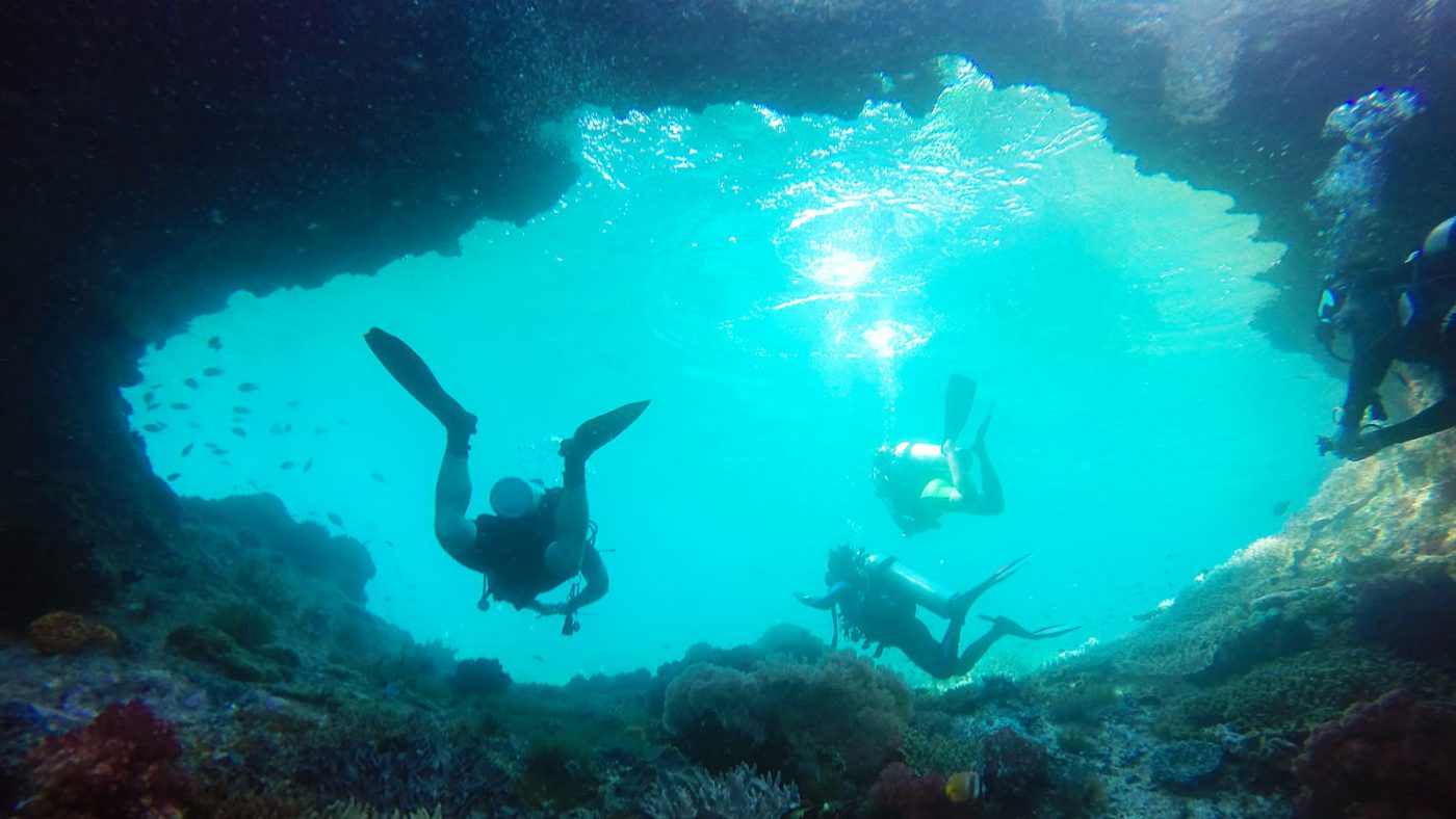 Swimming through a cave in Batu Rufus