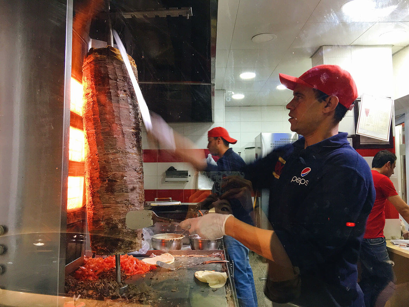 Shaving meat off the vertical spit for Shawarma wrap