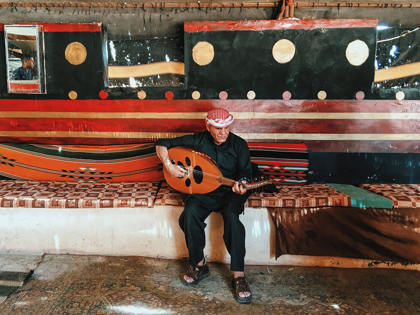 An old man playing Bedouin guitar